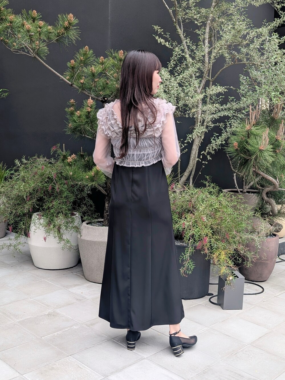 ブラック系のドレスを着用したレディースの春コーディネートの2枚目の写真