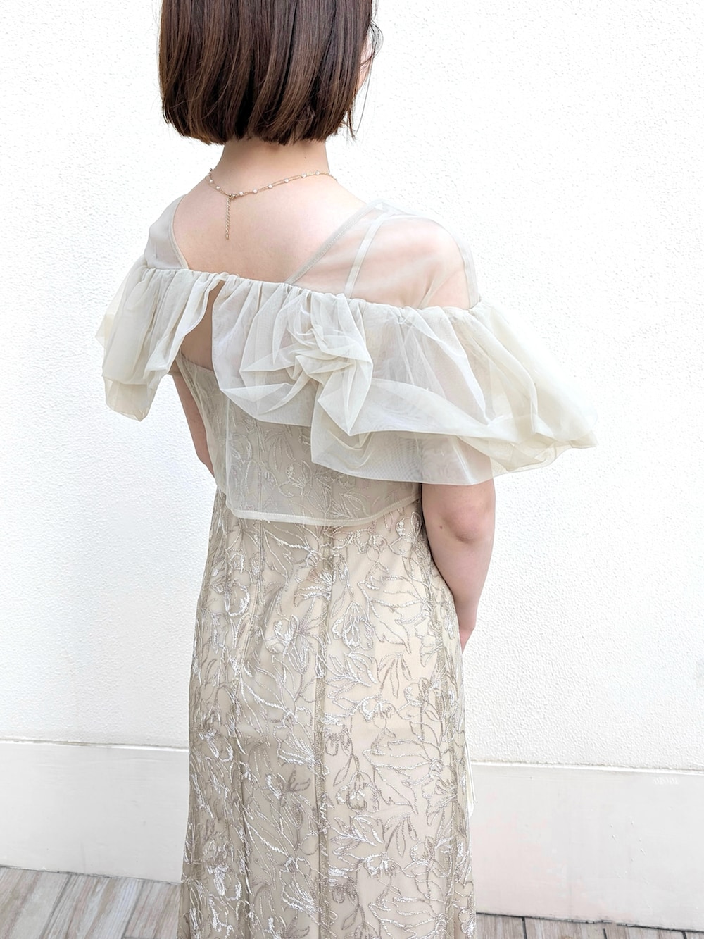 ブラック系のパンプス、ブラック系のワンピース/ドレス、ベージュ系のドレスを着用したレディースの春コーディネートの2枚目の写真