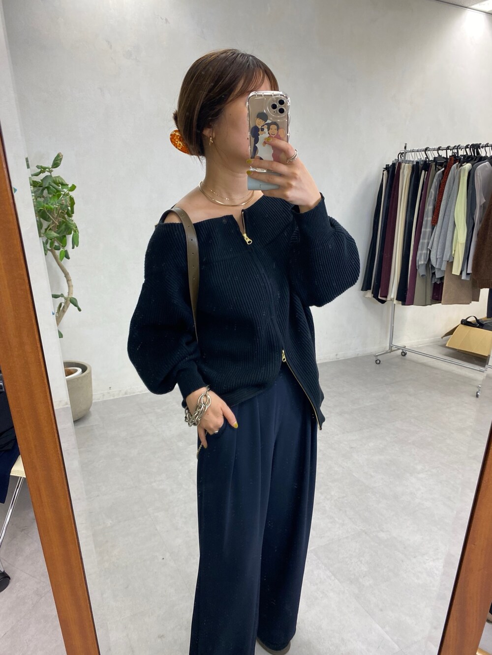 ブラック系のニット/セーター、ブルー系のスラックス、ゴールド系のサスペンダーを着用したレディースの秋コーディネートの2枚目の写真