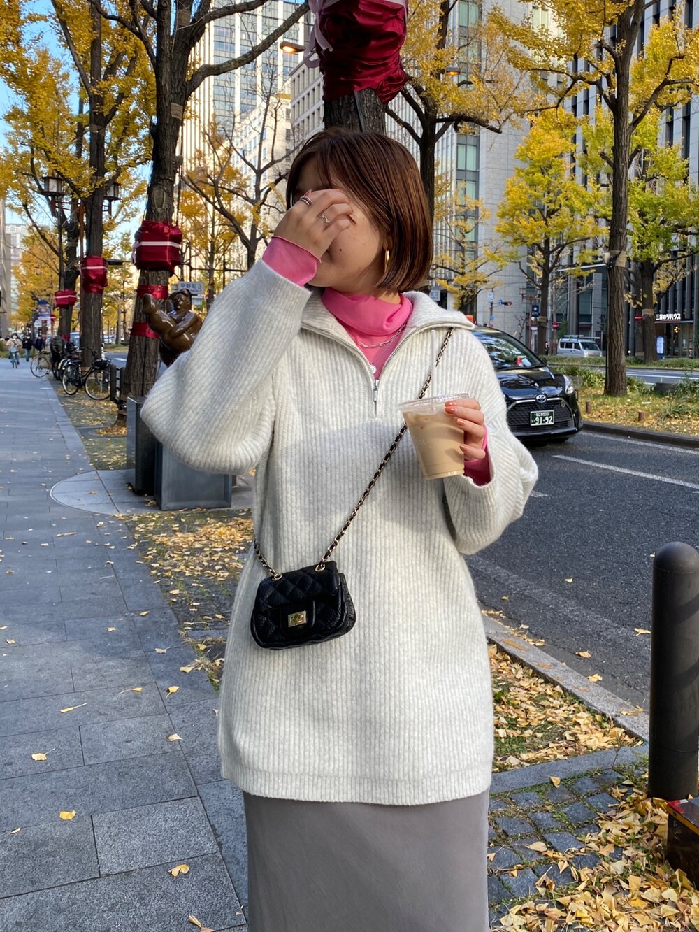 ピンク系のTシャツ/カットソー、グレー系のニット/セーター、グレー系のスカートを着用したレディースの冬コーディネートの5枚目の写真