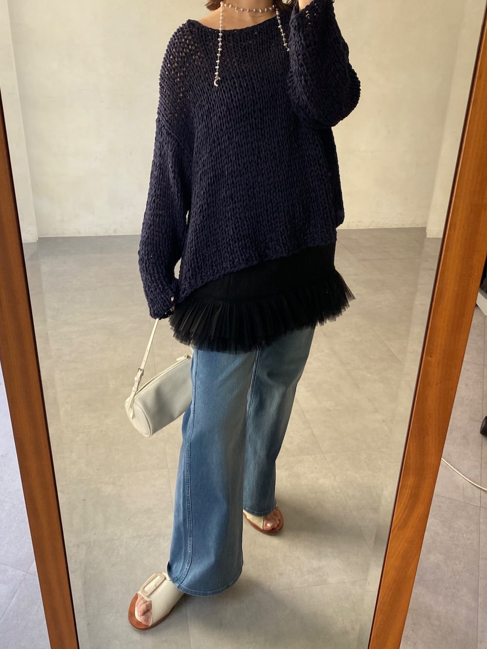 ブルー系のニット/セーター、ブラック系のシャツ/ブラウス、ブルー系のデニムパンツを着用したレディースの春コーディネートの9枚目の写真