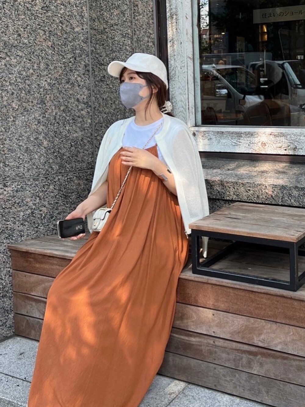 ブラウン系のワンピース、ホワイト系のショルダーバッグ、ホワイト系のカーディガン/ボレロを着用したレディースの夏コーディネートの2枚目の写真