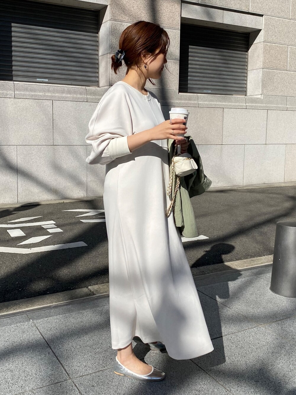 ホワイト系のワンピース、ブラック系のショルダーバッグを着用したレディースの春コーディネートの3枚目の写真