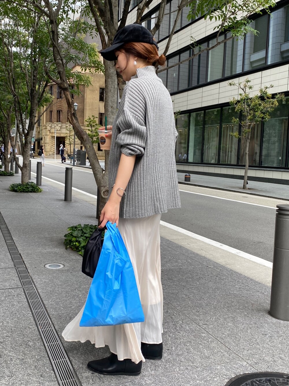 ベージュ系のワンピース、ホワイト系のスカート、ブラック系のブーツを着用したレディースの冬コーディネートの8枚目の写真