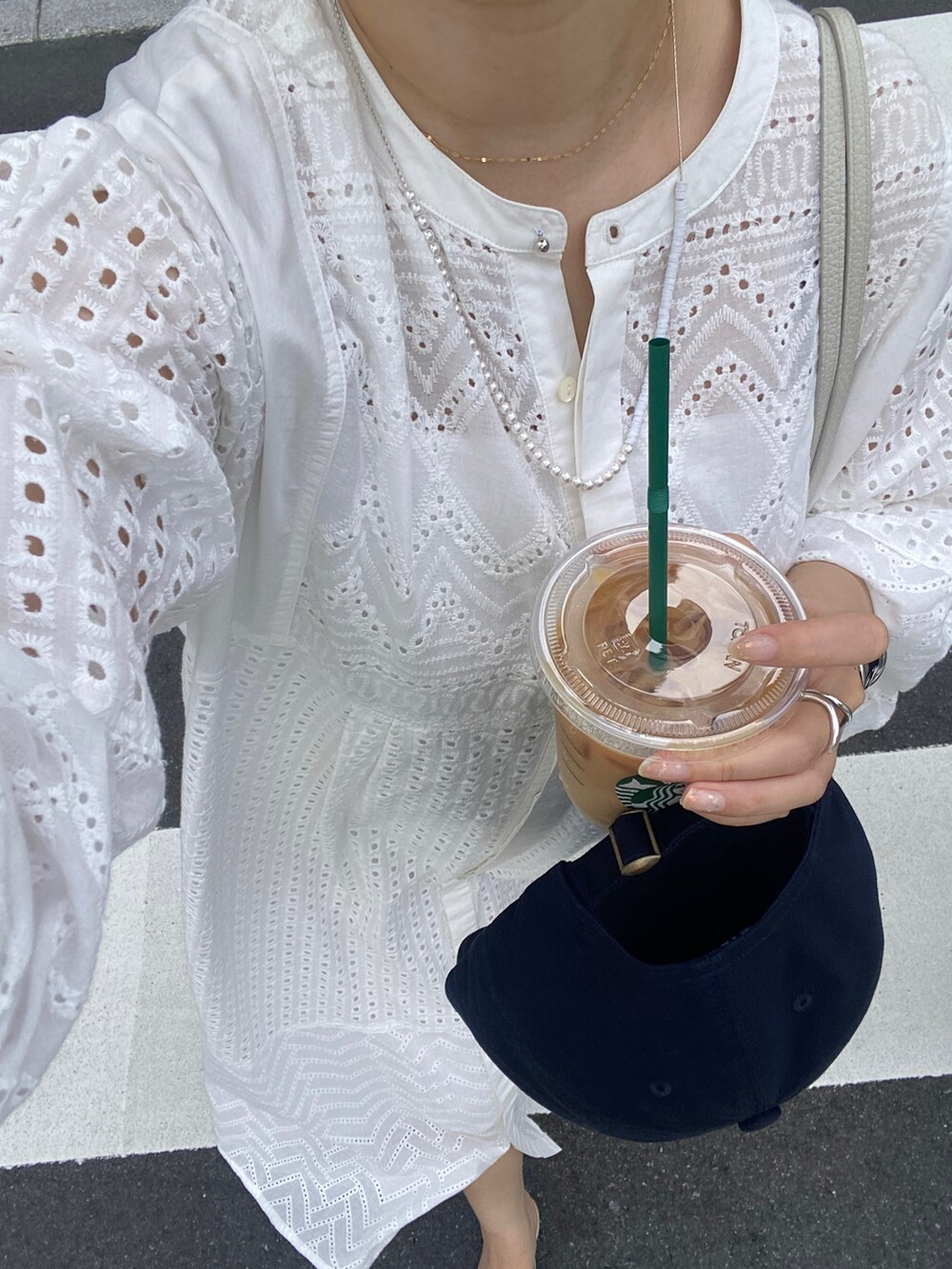 ホワイト系のワンピース、ホワイト系のショルダーバッグ、ゴールド系のブレスレットを着用したレディースの夏コーディネートの5枚目の写真