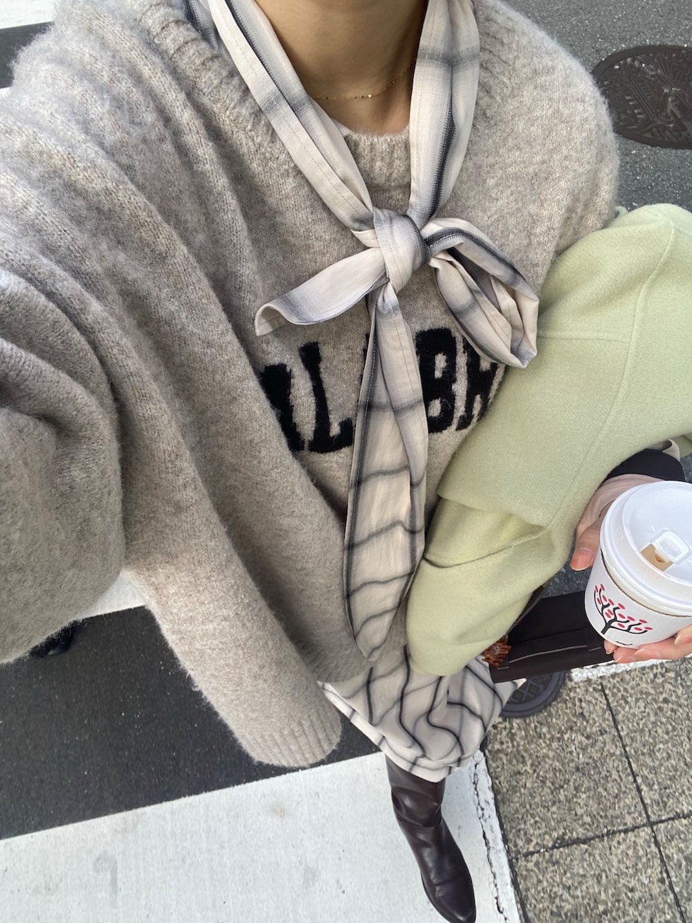 ホワイト系のワンピース、ホワイト系のニット/セーター、ブラウン系のブーツを着用したレディースの冬コーディネートの3枚目の写真