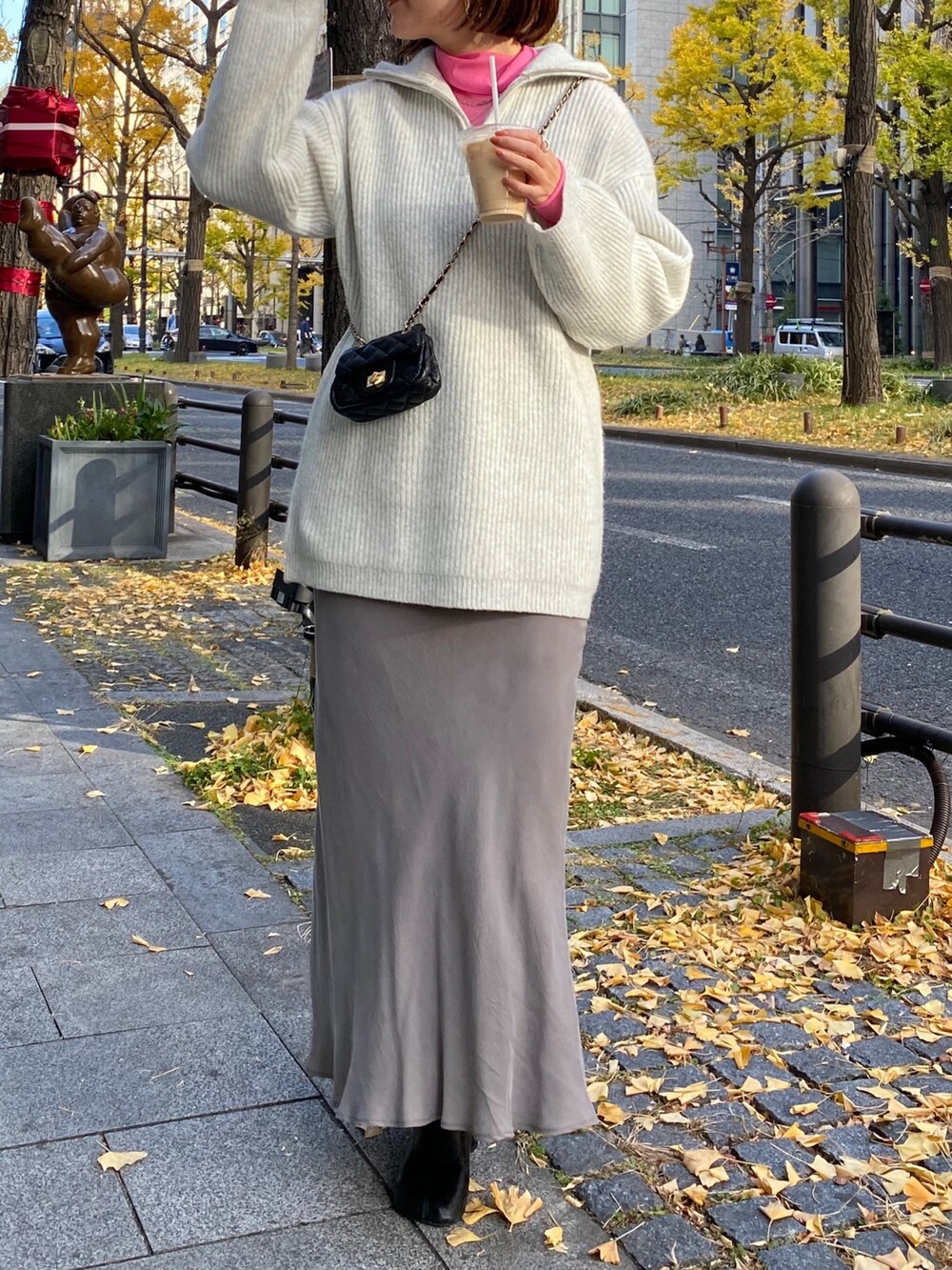 ピンク系のTシャツ/カットソー、グレー系のニット/セーター、グレー系のスカートを着用したレディースの冬コーディネートの7枚目の写真
