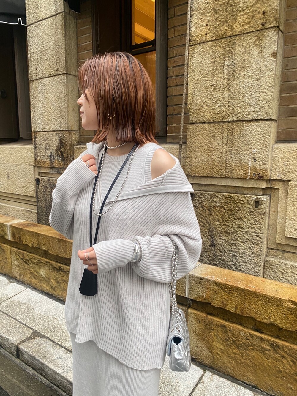 ホワイト系のブルゾン、グレー系のワンピース、シルバー系のショルダーバッグを着用したレディースの春コーディネートの8枚目の写真