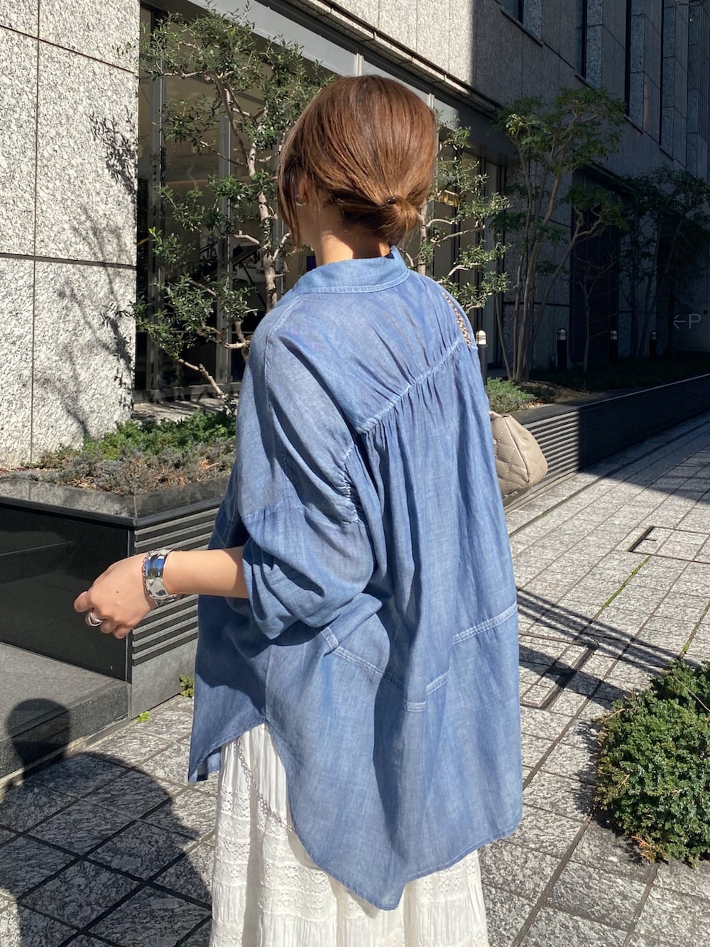 ブルー系のシャツ/ブラウス、ホワイト系のスカート、ホワイト系のTシャツ/カットソーを着用したレディースの春コーディネートの9枚目の写真