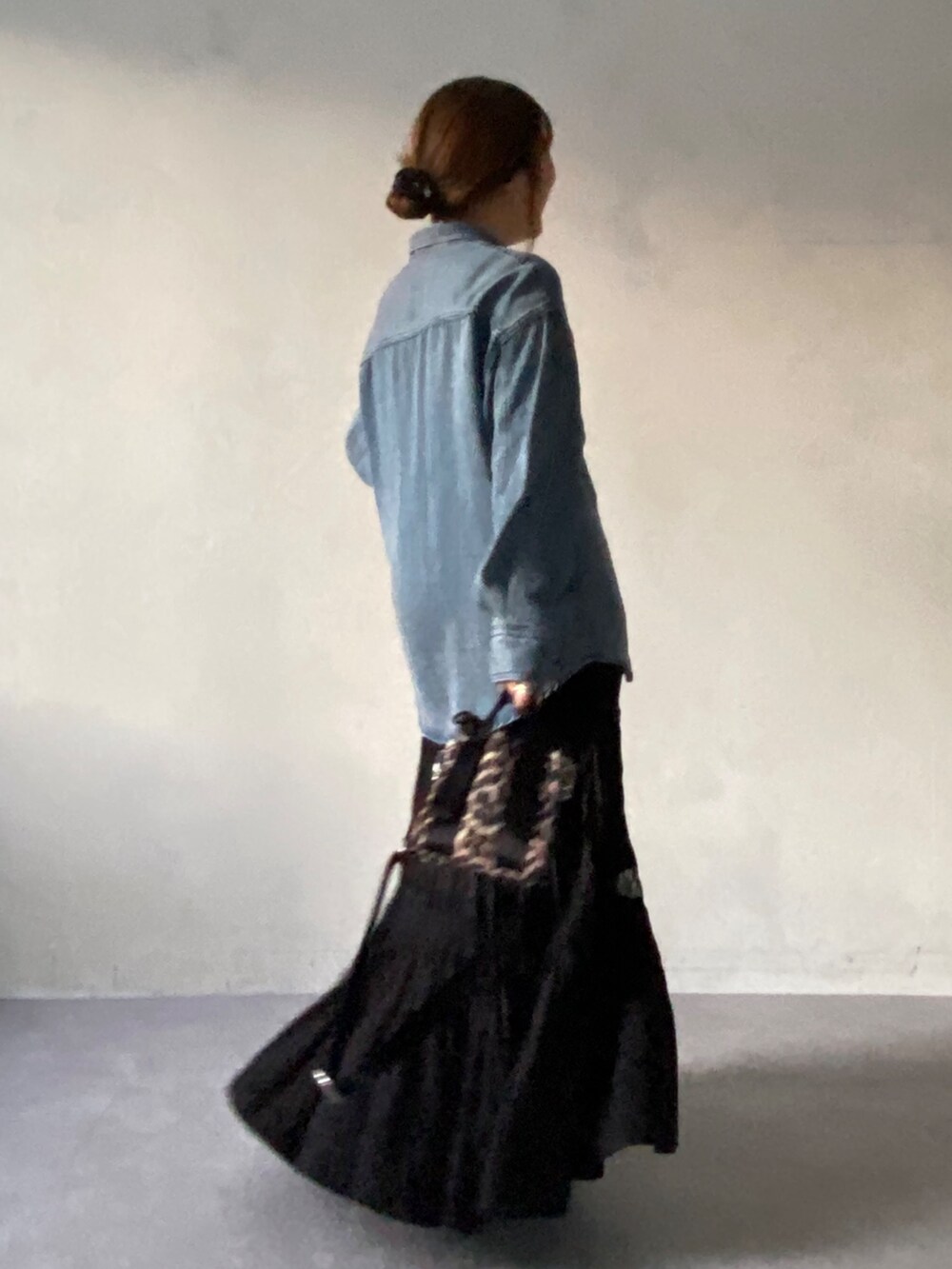 グレー系のムートンコート、ブルー系のシャツ/ブラウス、ブラック系のスカートを着用したレディースの冬コーディネートの6枚目の写真