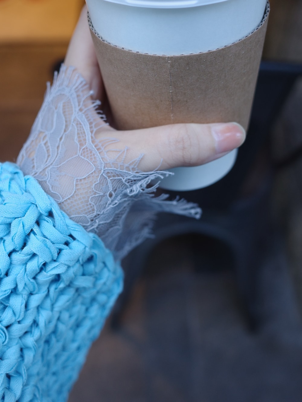 ブルー系のニット/セーター、グレー系のTシャツ/カットソー、グレー系のスラックスを着用したレディースの冬コーディネートの8枚目の写真