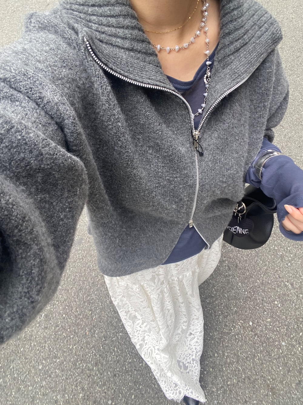 グレー系のカーディガン/ボレロ、ブルー系のTシャツ/カットソー、ホワイト系のスカートを着用したレディースの秋コーディネートの2枚目の写真