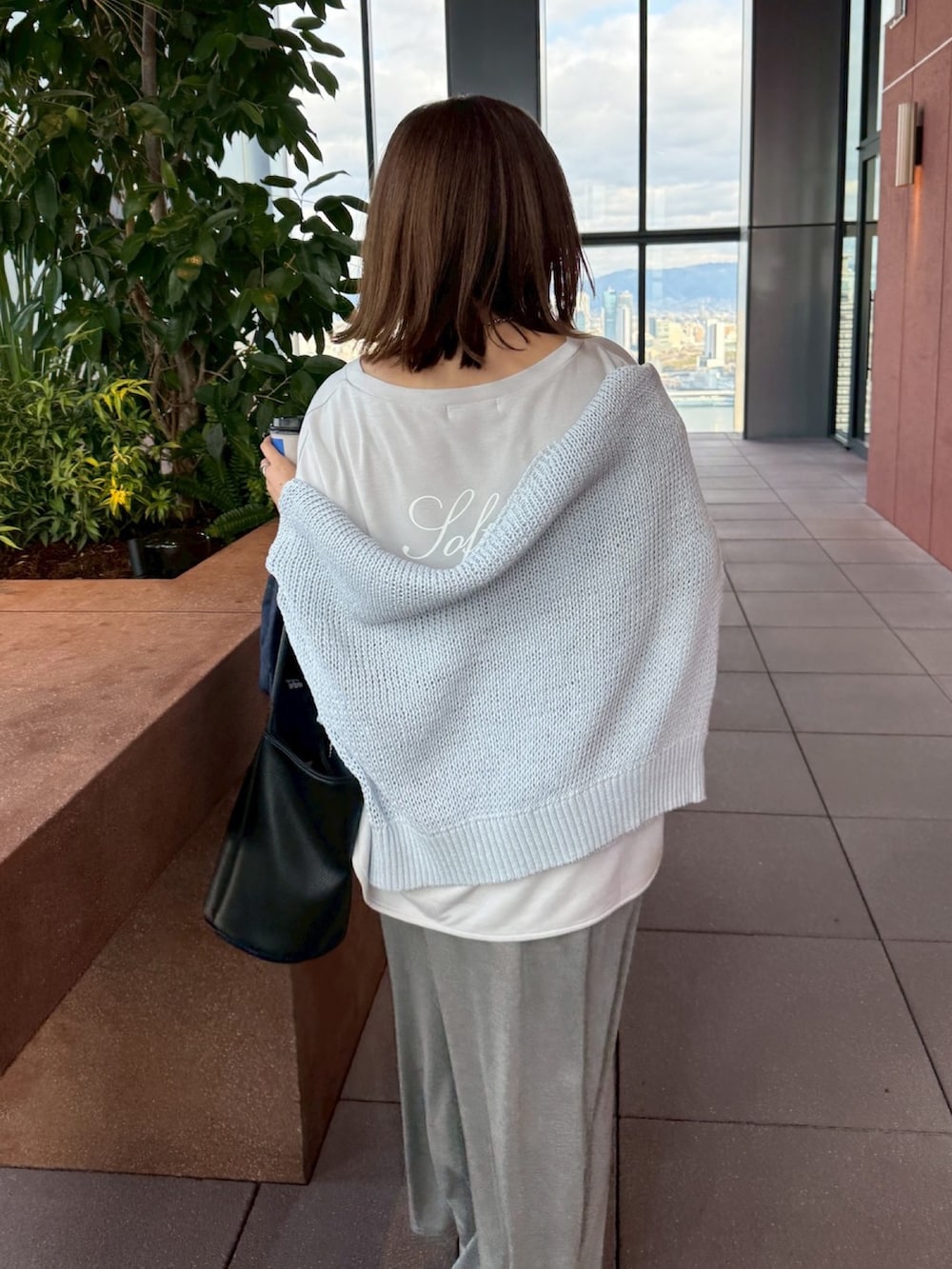 グレー系のTシャツ/カットソー、ブルー系のニット/セーター、グレー系のスカートを着用したレディースの冬コーディネートの6枚目の写真