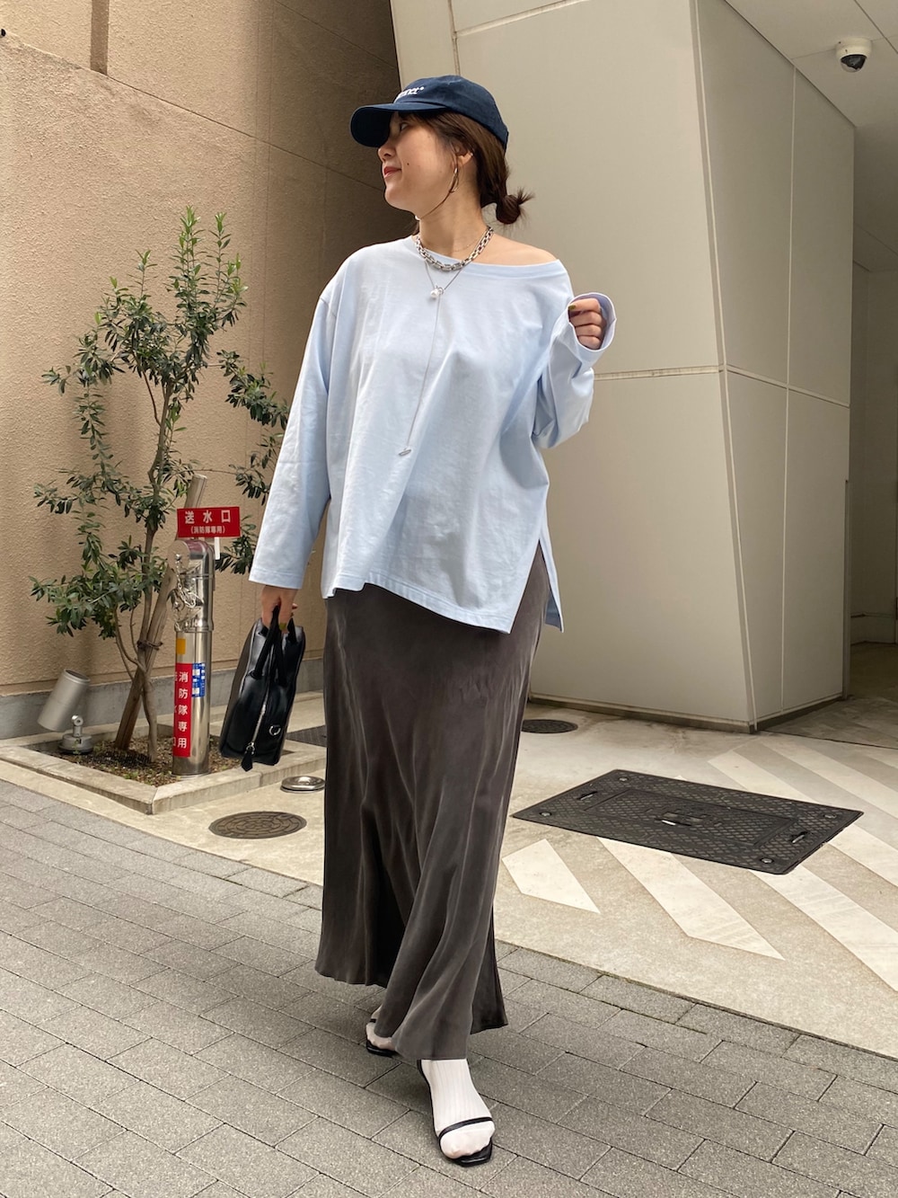 ブルー系のTシャツ/カットソー、ブラック系のスカート、ブラック系のショルダーバッグを着用したレディースの春コーディネートの8枚目の写真