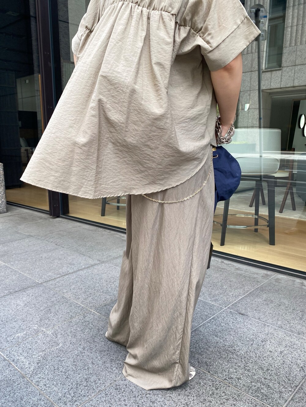 ベージュ系のシャツ/ブラウス、ブラック系のショルダーバッグ、ベージュ系のTシャツ/カットソーを着用したレディースの夏コーディネートの3枚目の写真