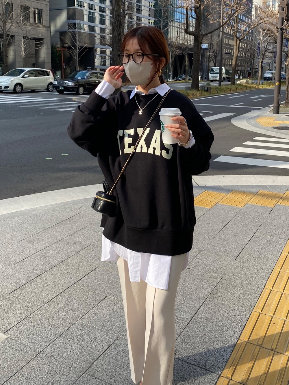 ブラック系のスウェット、ホワイト系のシャツ/ブラウス、ホワイト系のスラックスを着用したレディースの春コーディネートの4枚目の写真