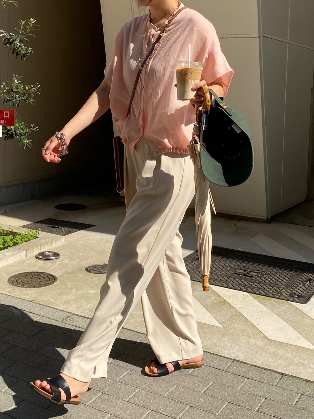 ピンク系のシャツ/ブラウス、ホワイト系のスラックス、ゴールド系のネックレスを着用したレディースの夏コーディネートの2枚目の写真