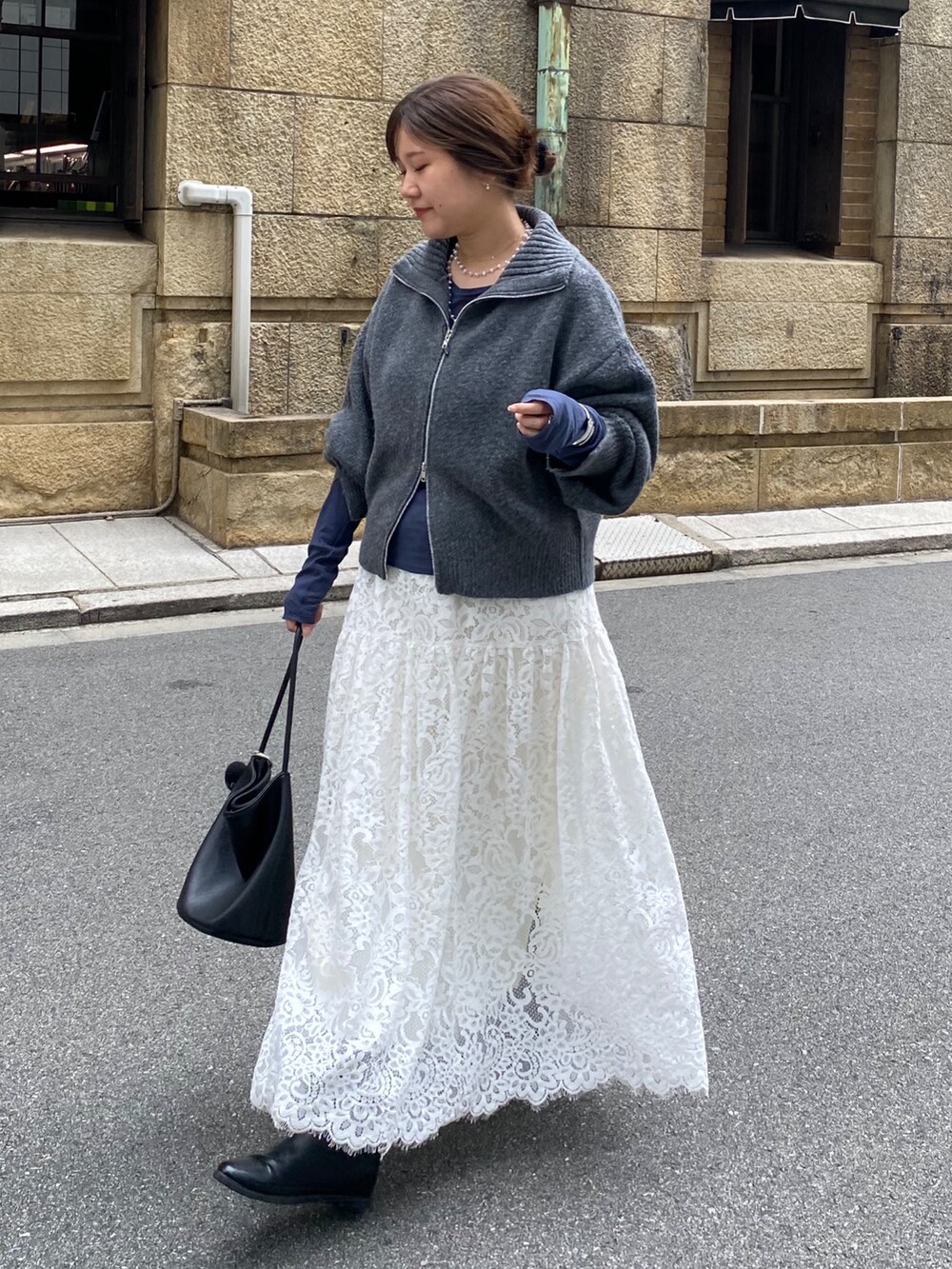 グレー系のカーディガン/ボレロ、ブルー系のTシャツ/カットソー、ホワイト系のスカートを着用したレディースの秋コーディネートの10枚目の写真