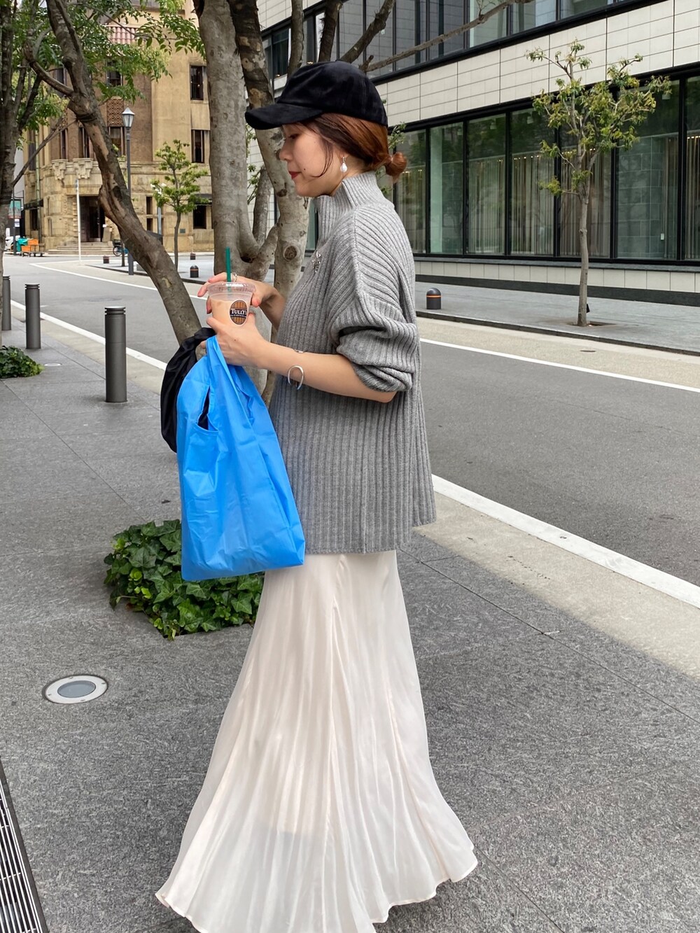 ベージュ系のワンピース、ホワイト系のスカート、ブラック系のブーツを着用したレディースの冬コーディネートの9枚目の写真