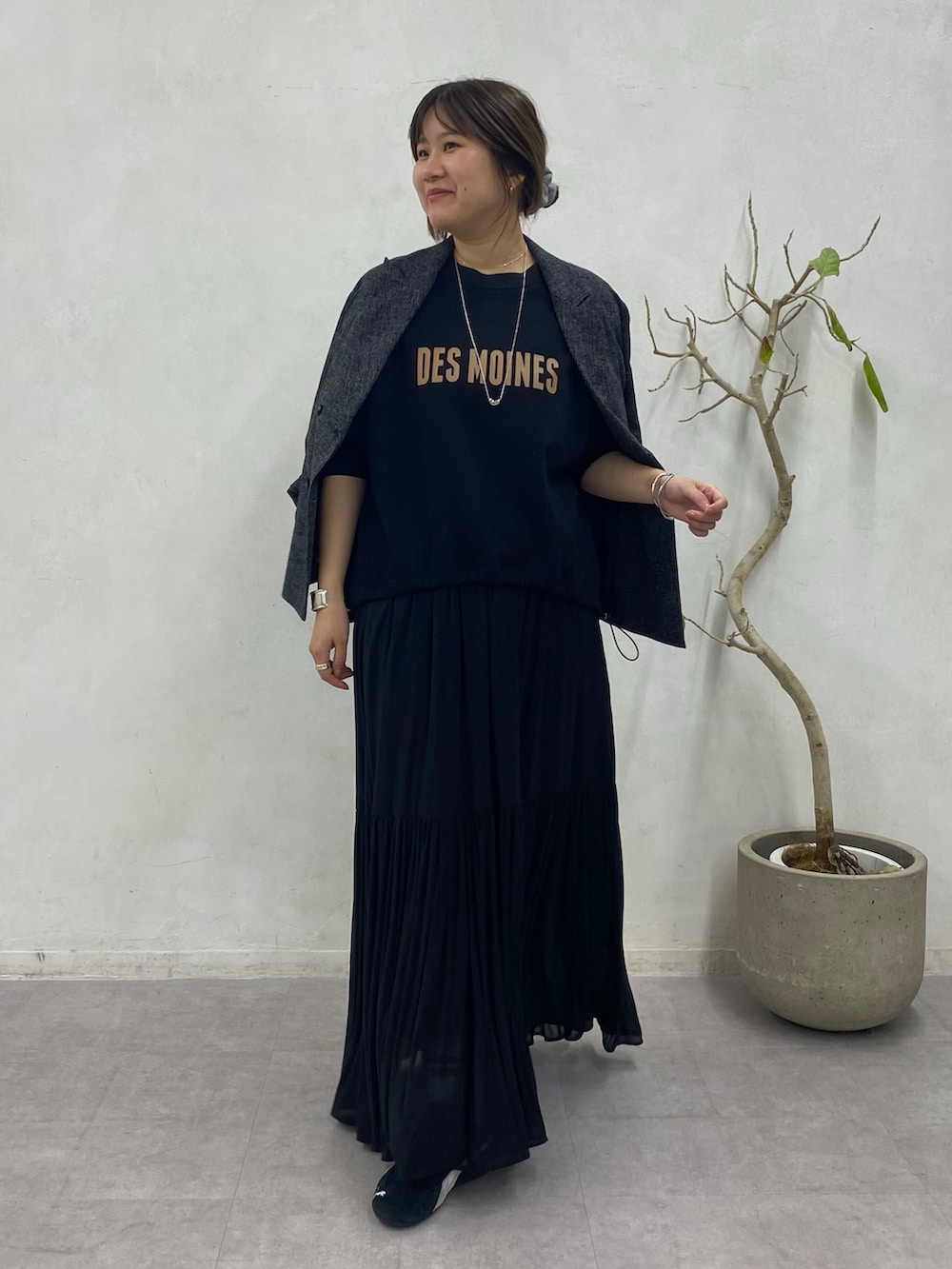 ブラック系のスウェット、ブラック系のスカート、ブラック系のテーラードジャケットを着用したレディースの冬コーディネートの2枚目の写真