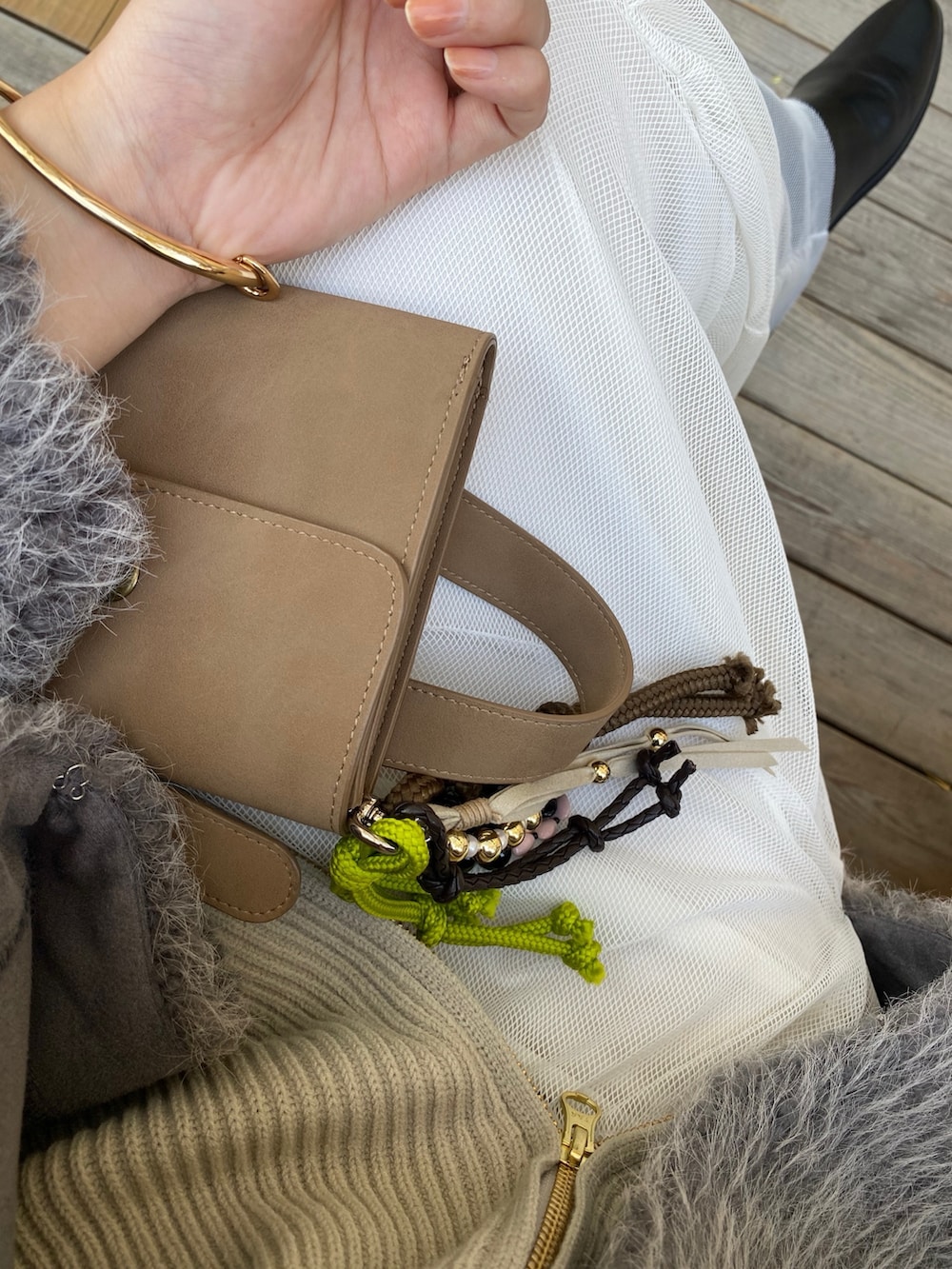 ベージュ系のニット/セーター、ホワイト系のスカート、グレー系のその他アウターを着用したレディースの冬コーディネートの8枚目の写真