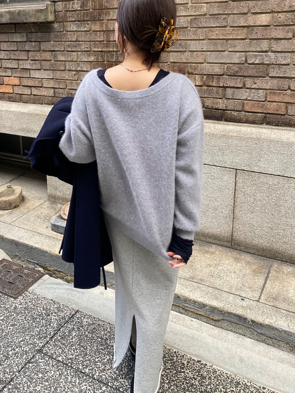 ブルー系のその他アウター、グレー系のニット/セーター、グレー系のスカートを着用したレディースの冬コーディネートの5枚目の写真