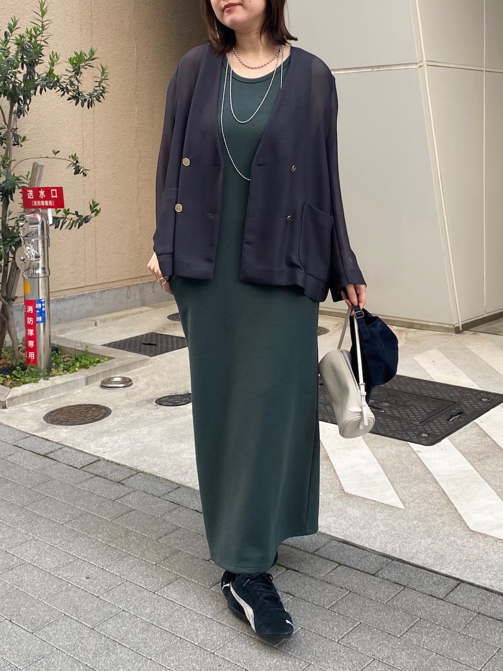 グレー系のテーラードジャケット、グリーン系のワンピースを着用したレディースの春コーディネートの10枚目の写真