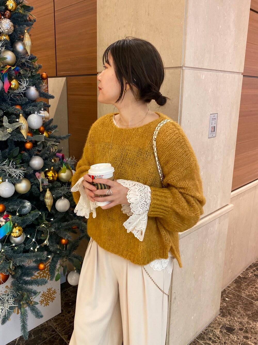 ベージュ系のその他アウター、イエロー系のニット/セーター、ホワイト系のシャツ/ブラウスを着用したレディースの冬コーディネートの3枚目の写真