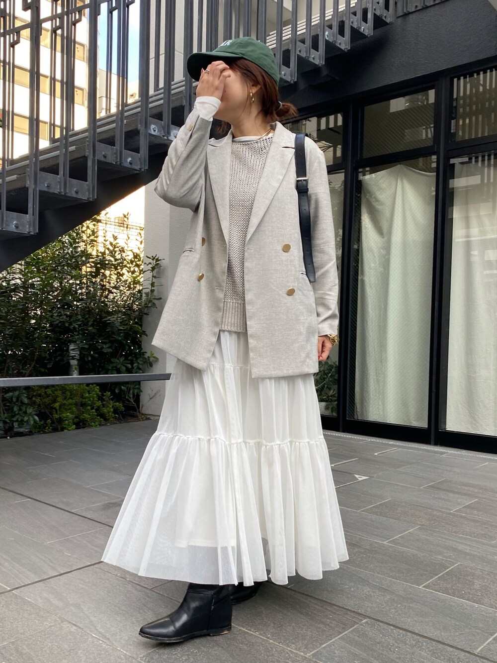 ホワイト系のニット/セーター、グレー系のテーラードジャケット、グリーン系のスカートを着用したレディースの春コーディネートの8枚目の写真