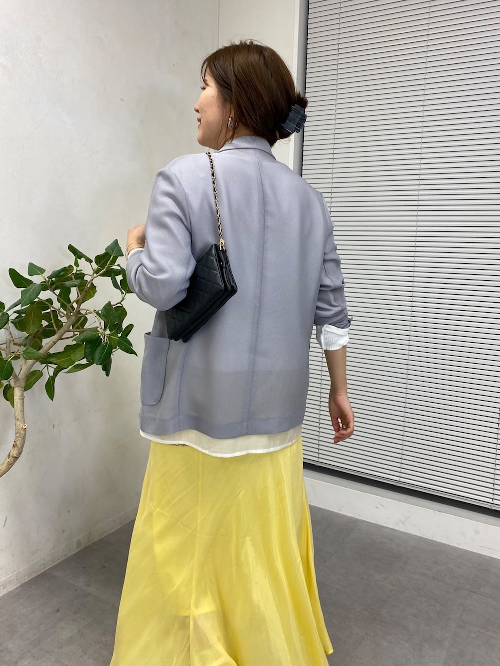 イエロー系のスカート、ホワイト系のシャツ/ブラウス、ブラック系のショルダーバッグを着用したレディースの冬コーディネートの6枚目の写真