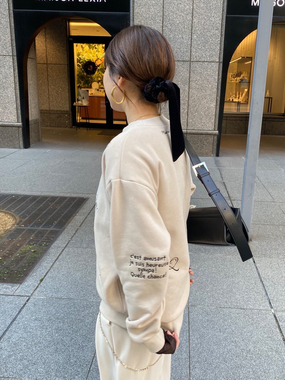 ホワイト系のその他アウター、ベージュ系のスラックス、ブラック系のショルダーバッグを着用したレディースの秋コーディネートの7枚目の写真