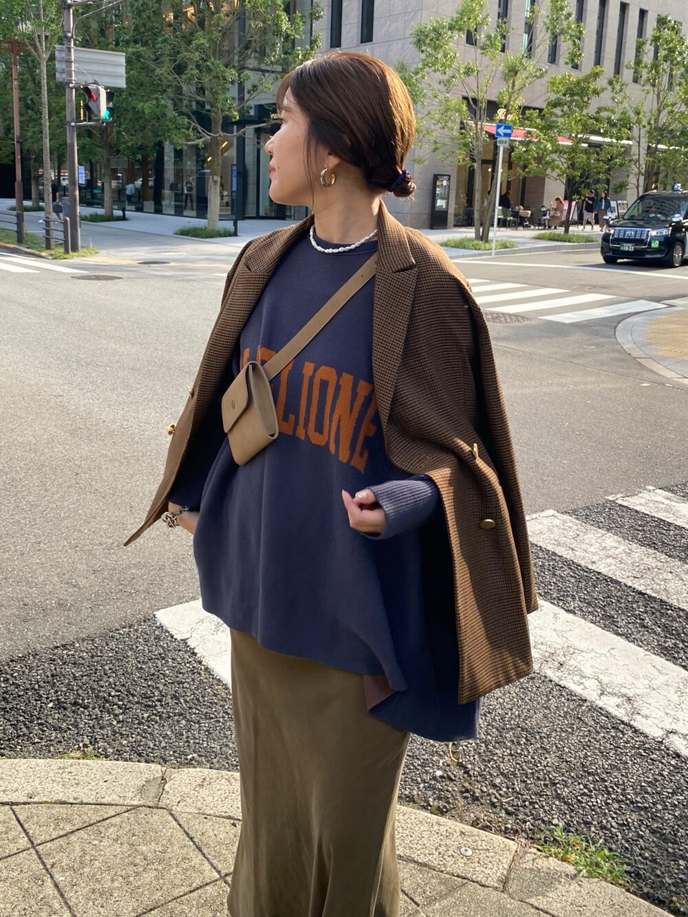 ブルー系のニット/セーター、グリーン系のスカート、ブラウン系のテーラードジャケットを着用したレディースの秋コーディネートの6枚目の写真