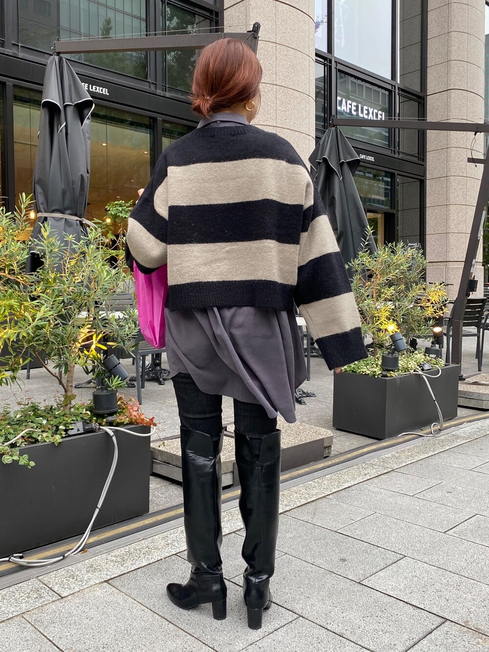 グレー系のシャツ/ブラウス、ブラック系のデニムパンツ、ブラック系のブーツを着用したレディースの冬コーディネートの3枚目の写真