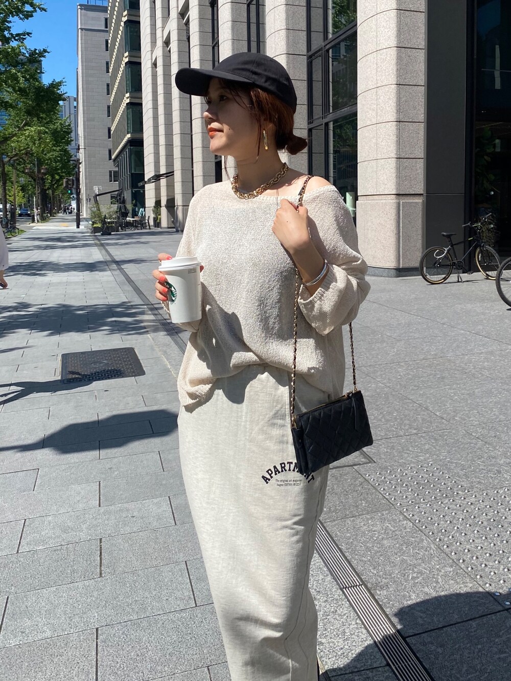 ベージュ系のニット/セーター、ベージュ系のスカート、ブラック系のショルダーバッグを着用したレディースの夏コーディネートの5枚目の写真