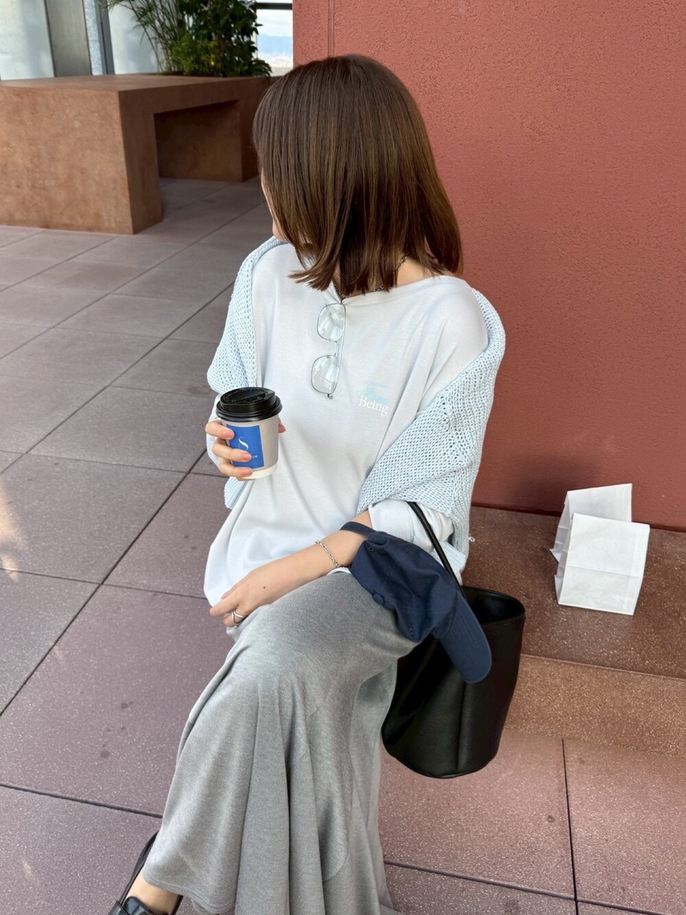 グレー系のTシャツ/カットソー、ブルー系のニット/セーター、グレー系のスカートを着用したレディースの冬コーディネートの5枚目の写真