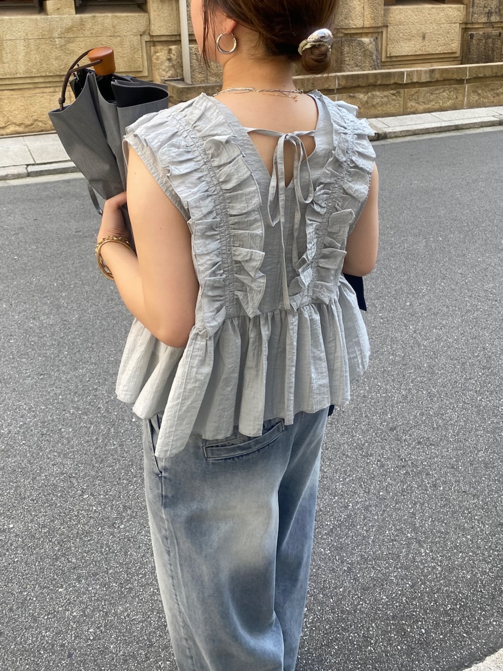 グレー系のシャツ/ブラウス、ブルー系のデニムパンツ、シルバー系のショルダーバッグを着用したレディースの夏コーディネートの5枚目の写真