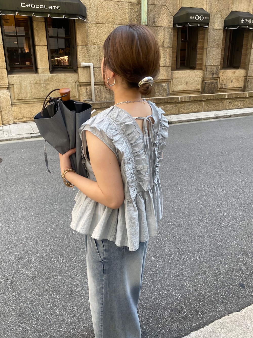 グレー系のシャツ/ブラウス、ブルー系のデニムパンツ、シルバー系のショルダーバッグを着用したレディースの夏コーディネートの4枚目の写真