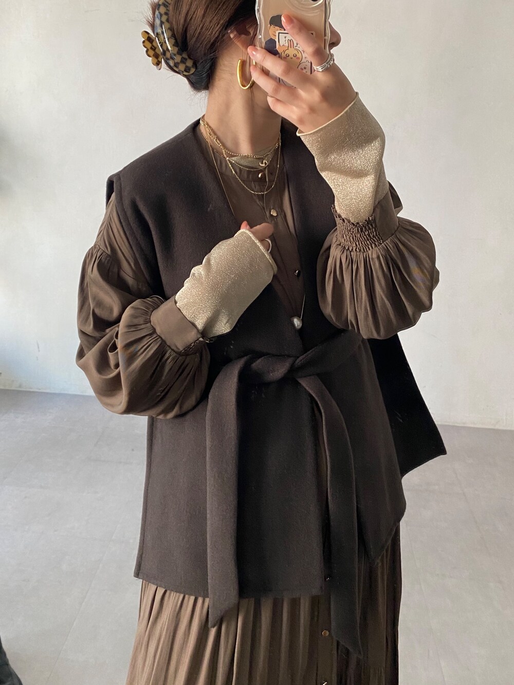 ブラウン系のベスト、ブラウン系のテーラードジャケット、ブラウン系のワンピースを着用したレディースの冬コーディネートの6枚目の写真