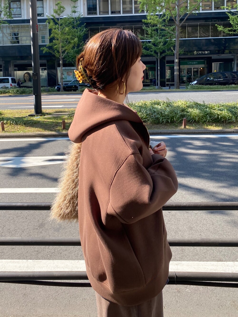 ブラウン系のTシャツ/カットソー、ブラウン系のスカート、ベージュ系のショルダーバッグを着用したレディースの冬コーディネートの2枚目の写真