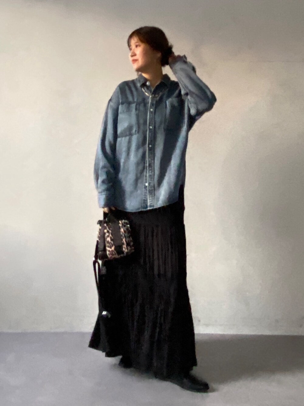 グレー系のムートンコート、ブルー系のシャツ/ブラウス、ブラック系のスカートを着用したレディースの冬コーディネートの7枚目の写真