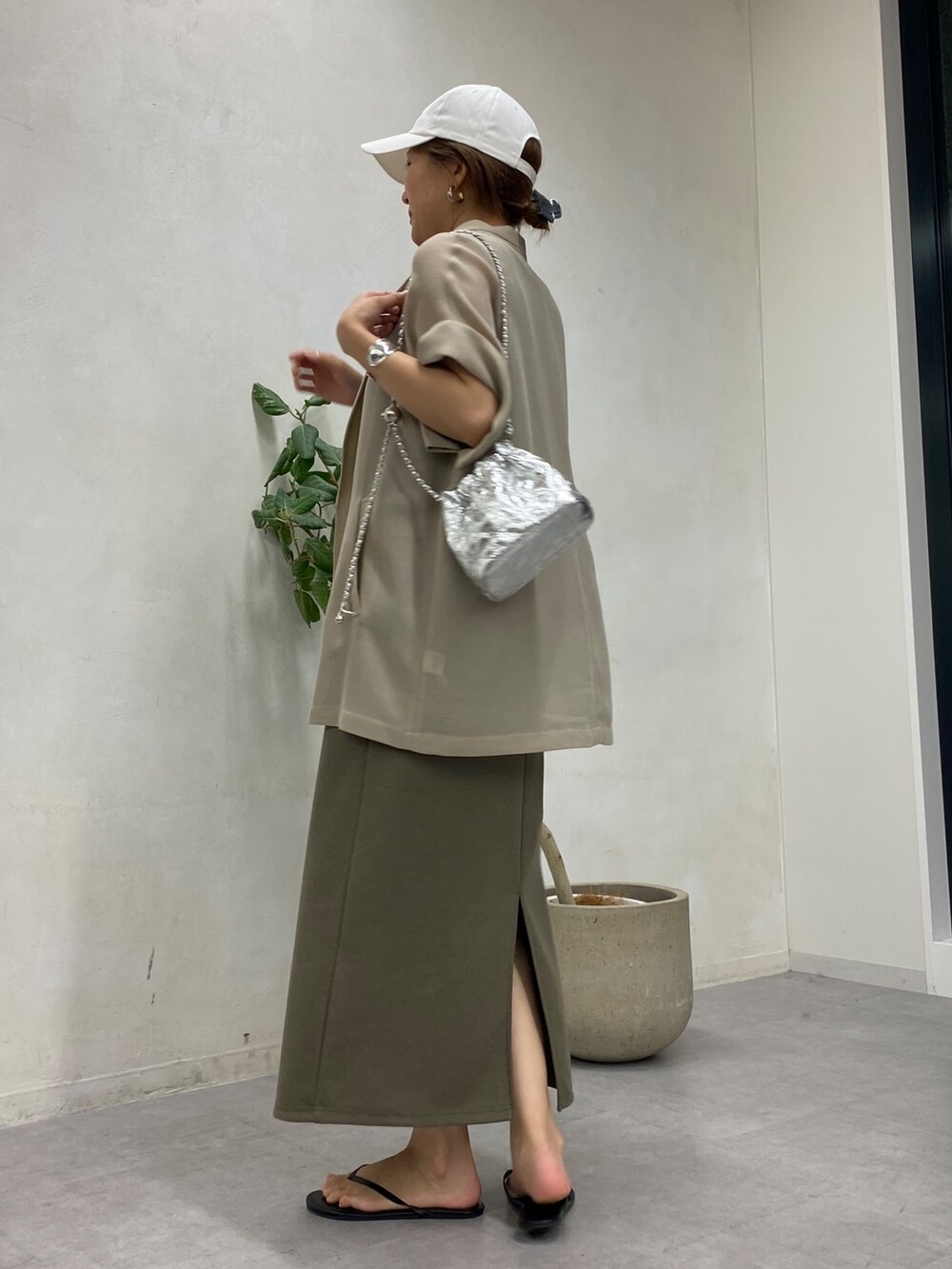 ベージュ系のテーラードジャケット、グリーン系のワンピース、シルバー系のショルダーバッグを着用したレディースの春コーディネートの5枚目の写真