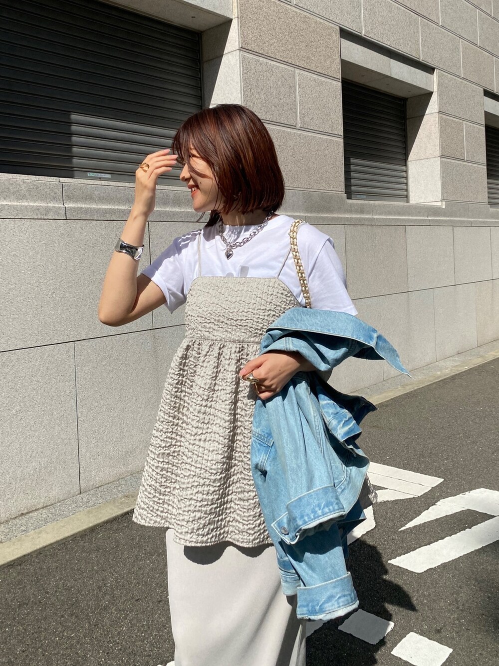 グレー系のキャミソール、ベージュ系のスカート、ブルー系のジャケット/アウターを着用したレディースの春コーディネートの2枚目の写真