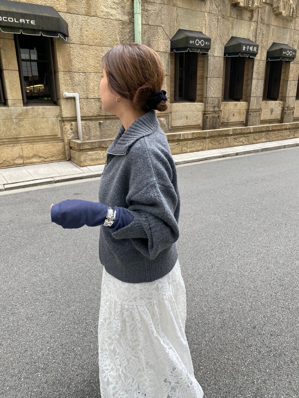 グレー系のカーディガン/ボレロ、ブルー系のTシャツ/カットソー、ホワイト系のスカートを着用したレディースの秋コーディネートの3枚目の写真