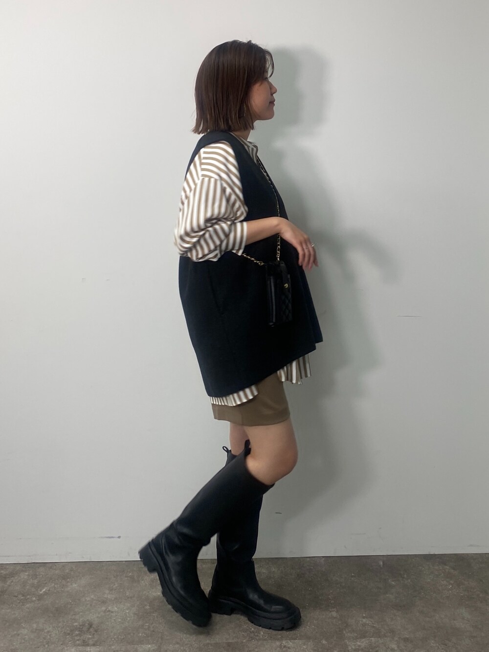 グレー系のベスト、ベージュ系のシャツ/ブラウス、イエロー系のその他パンツを着用したレディースの秋コーディネートの2枚目の写真