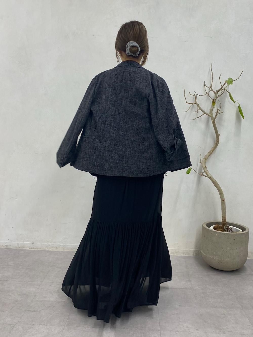 ブラック系のスウェット、ブラック系のスカート、ブラック系のテーラードジャケットを着用したレディースの冬コーディネートの8枚目の写真