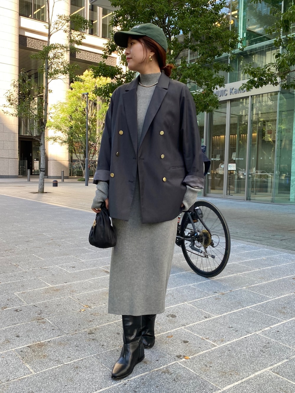 グレー系のテーラードジャケット、ベージュ系のワンピース、ブラック系のブーツを着用したレディースの冬コーディネートの8枚目の写真