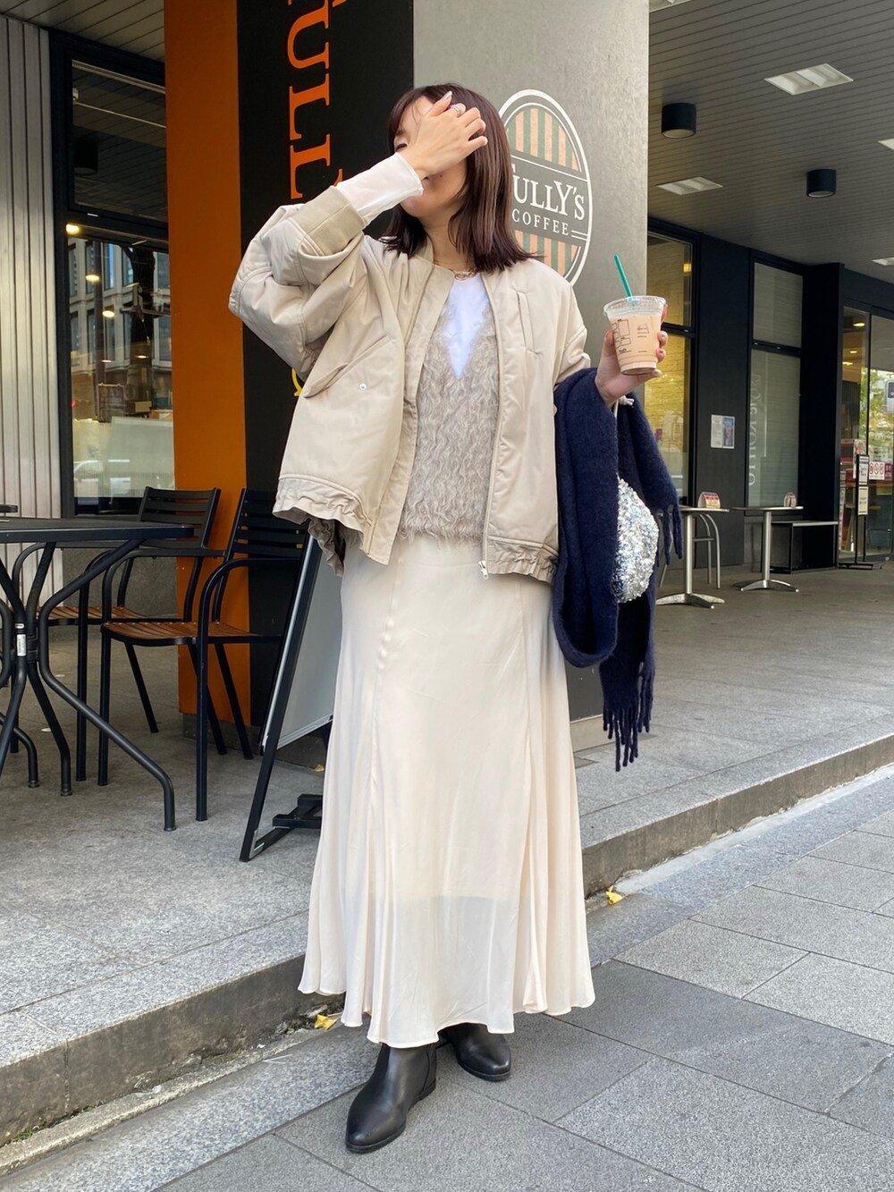 ベージュ系のMA-1、ベージュ系のベスト、ホワイト系のスカートを着用したレディースの秋コーディネートの9枚目の写真