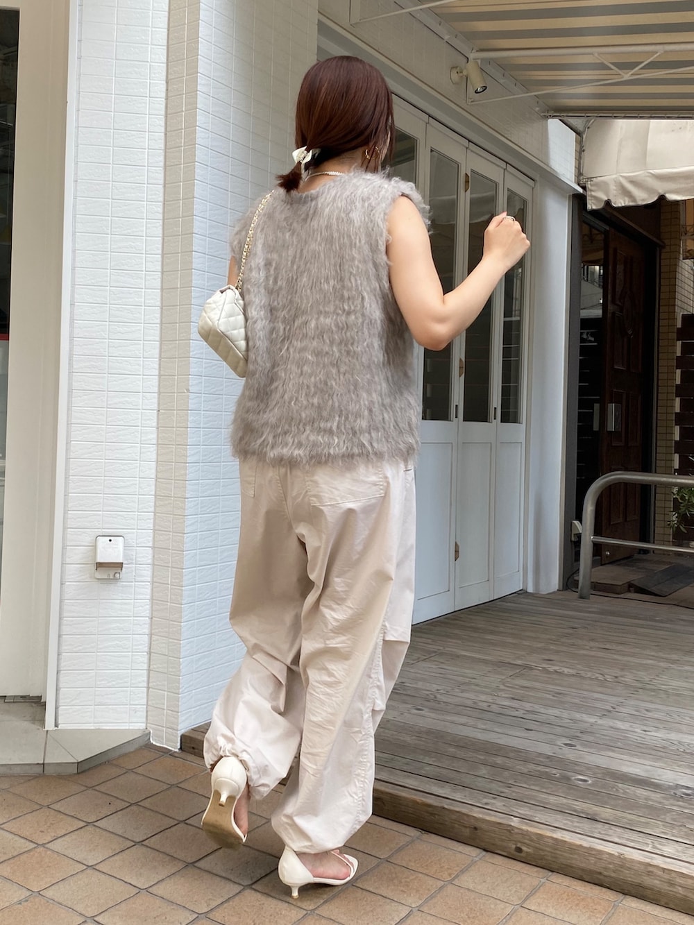 ベージュ系のベスト、ベージュ系のその他パンツ、ホワイト系のタンクトップを着用したレディースの秋コーディネートの8枚目の写真