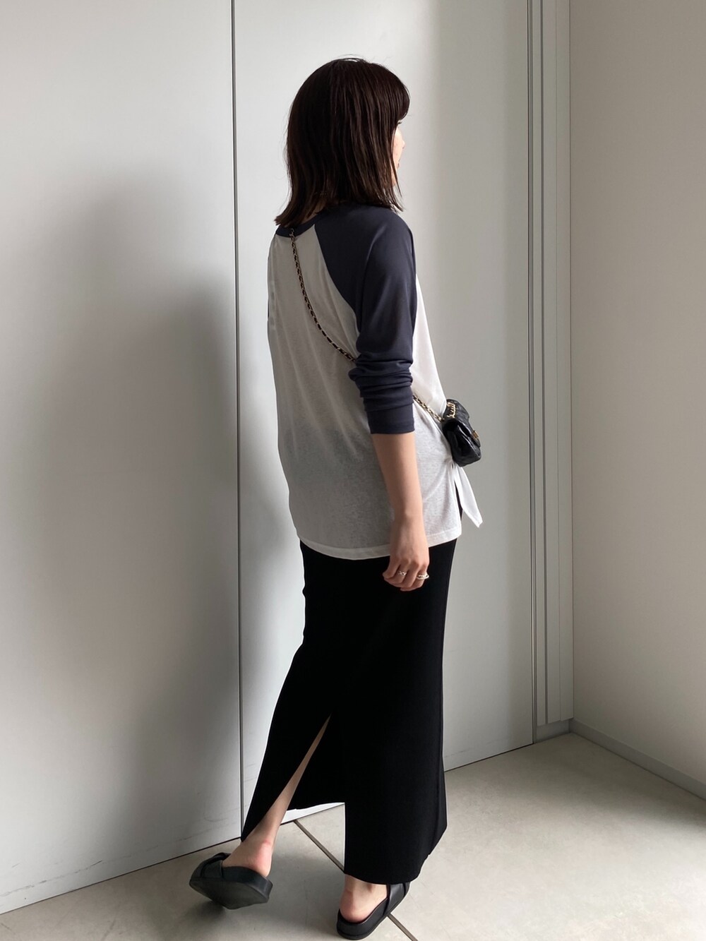 ホワイト系のTシャツ/カットソー、ブラック系のスカート、ブラック系のショルダーバッグを着用したレディースの夏コーディネートの5枚目の写真