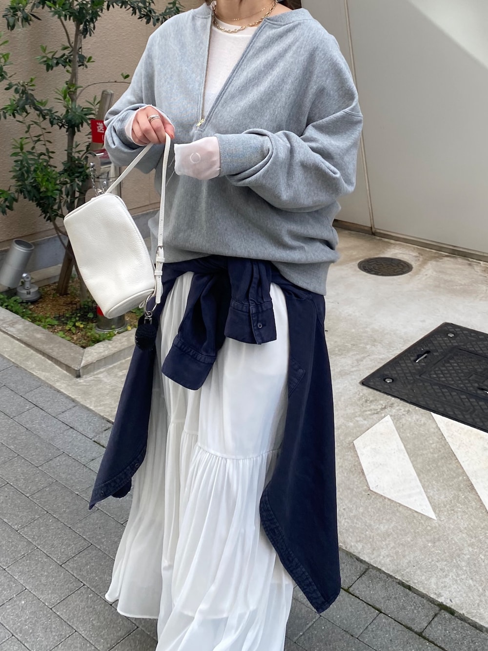 グレー系のスウェット、ブルー系のシャツ/ブラウス、ホワイト系のスカートを着用したレディースの冬コーディネートの6枚目の写真